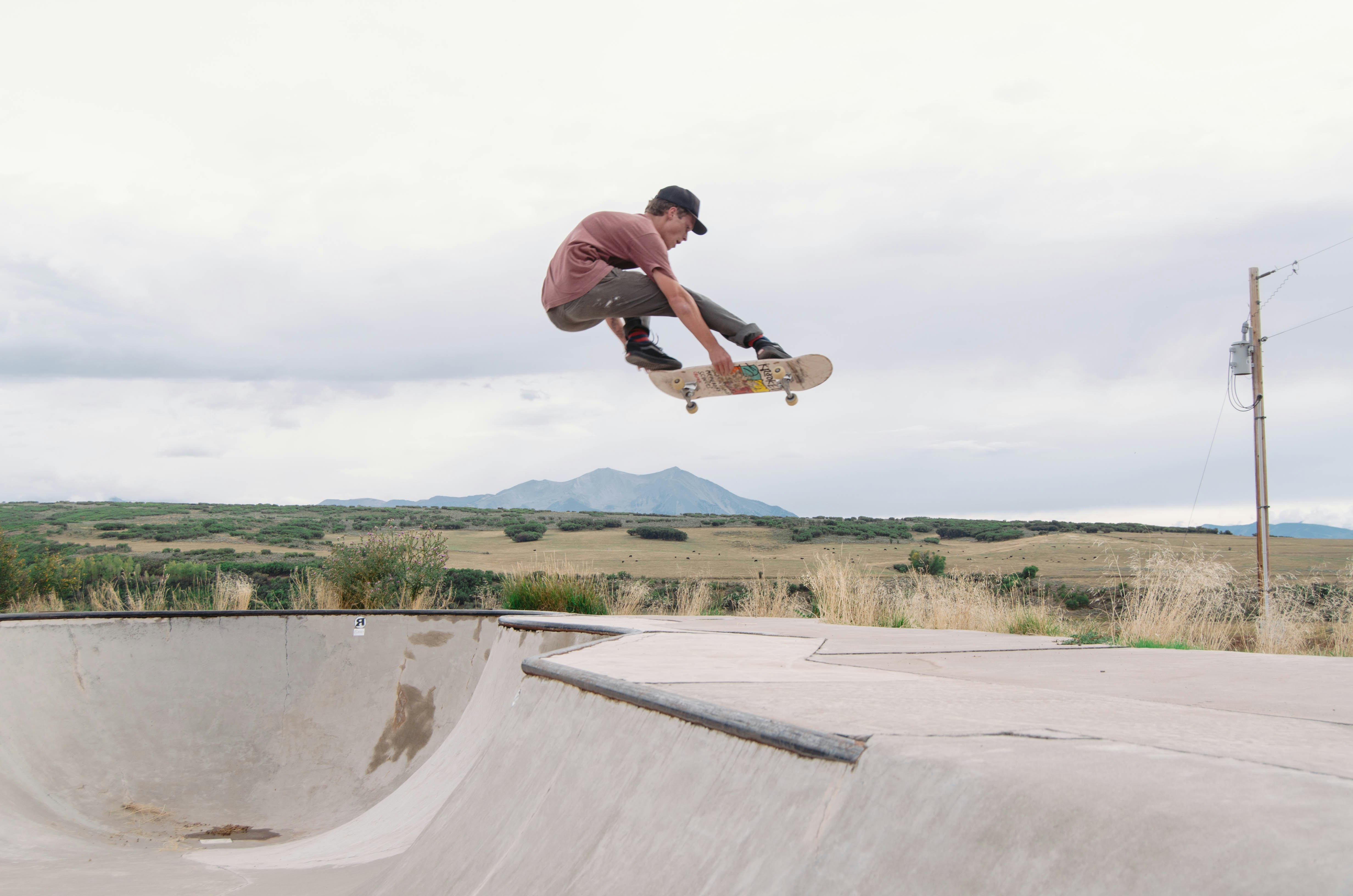 man riding skateboard in air during daytime